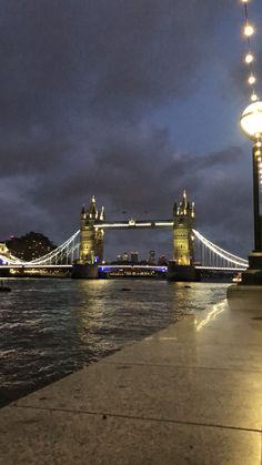 the tower bridge is lit up at night