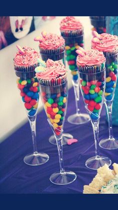 cupcakes and candy in wine glasses on a purple tablecloth with confetti