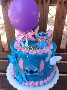 a blue cake with pink and purple decorations