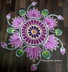 an artistically designed rangolite design with flowers on wood floor for diwaling