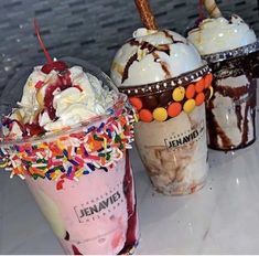 three ice cream sundaes with sprinkles and toppings on them