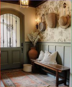 a bench with pillows and baskets on it in front of a door that leads to another room