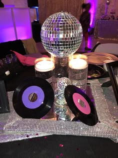 a table topped with disco balls and candles