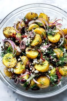 a glass bowl filled with potatoes and onions