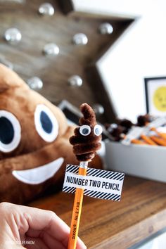 a person holding a pencil in front of a stuffed animal