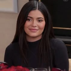 a woman sitting at a table with wine glasses