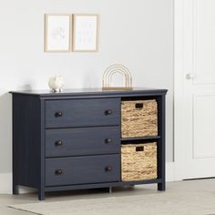 a black dresser with two baskets on top and one drawer open in front of it