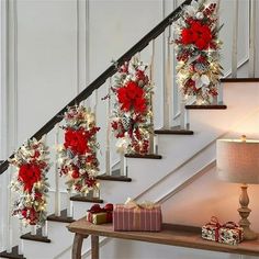 christmas decorations on the banisters and stairs in a home decorated with pine cones, poinsettis and red flowers