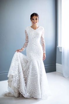 a woman in a white wedding dress posing for a photo with her hands on her hips