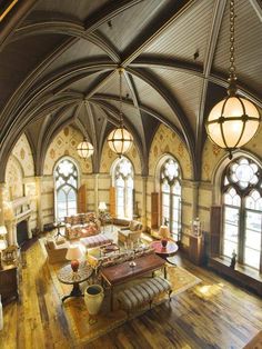 a large living room with wooden floors and arched windows