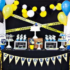 a table topped with cake and balloons next to a caution tape line on the wall