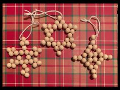 two wooden beads are attached to string on a plaid tablecloth