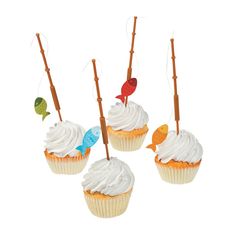 four cupcakes with white frosting and decorations on sticks in the shape of fish