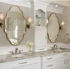 a bathroom with double sinks and two mirrors on the wall next to eachother