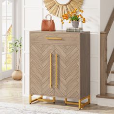 a wooden cabinet with gold handles in front of a stair case and mirror above it