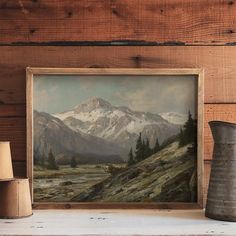 a painting on a mantle next to a vase and other items in front of a wood paneled wall