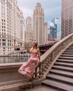 a woman in a pink dress standing on some steps