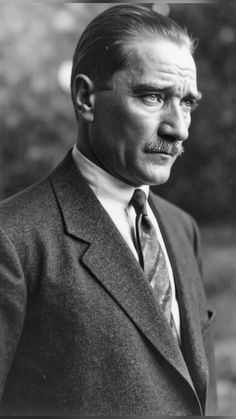 an old black and white photo of a man in a suit with a moustache