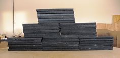 a stack of black slates sitting on top of a table next to a lamp