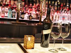 two wine glasses sitting on top of a bar