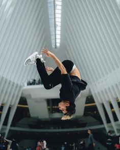 a person doing a handstand in the middle of a room with many people