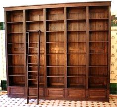 an old wooden bookcase with ladders on the floor in front of tiled walls