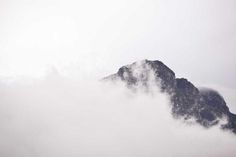 the top of a mountain is obscured by clouds