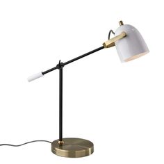 a white and gold desk lamp with a black metal base on an isolated white background