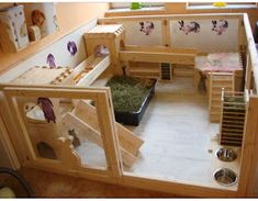 an indoor play area made out of wooden pallets with animals in the cages