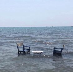 two chairs sitting in the middle of some water