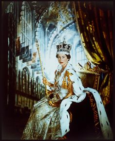 an old photo of queen elizabeth in her coronation dress and tiara sitting on a chair