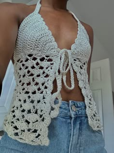 a woman wearing a white crochet halter top