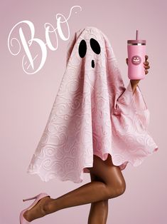 a woman holding a pink cup with a ghost on it's head and legs