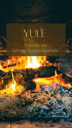 an open fire with the words yule written in german and english on it's side