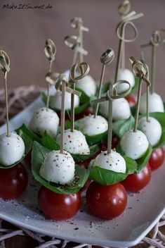 small appetizers with tomatoes and mozzarella are on a white platter