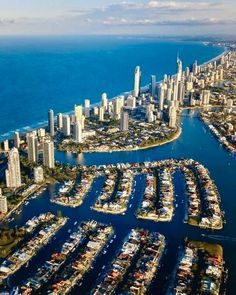 an aerial view of a city and harbor with many boats in the water, surrounded by tall buildings