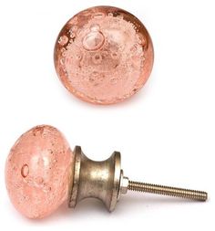 two pink glass knobs and a screw