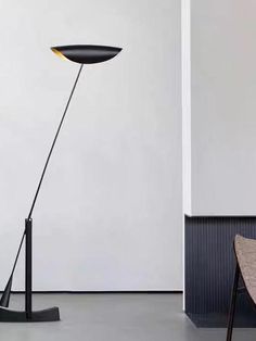 a floor lamp sitting on top of a table next to a chair