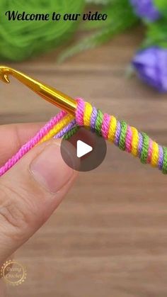 a person holding a yellow and pink crochet hook in their hand with the words welcome to our video on it