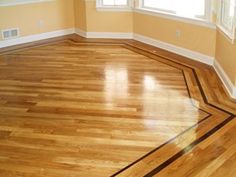 an empty room with hard wood flooring and white trim on the windows sill