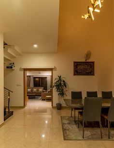 a dining room table and chairs in front of a staircase