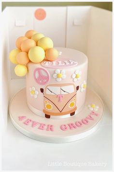 a pink cake decorated with flowers and a vw bus