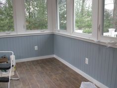 an empty room with several windows and chairs on the floor, in front of them