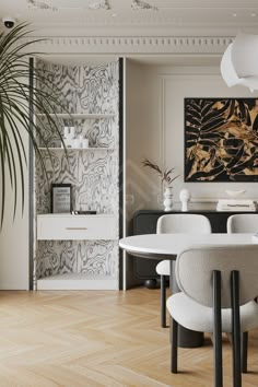 an elegant dining room with white chairs and art on the wall