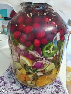 a large jar filled with lots of different types of fruit and vegtables