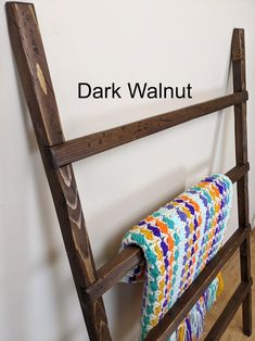 a blanket is hanging on the back of an old wooden rack with text over it that reads dark walnut