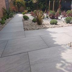 an outdoor patio area with various plants and rocks