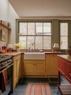 a kitchen with wooden cabinets and an area rug in front of the sink that matches the cabinetry