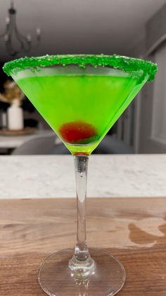 a green and red drink sitting on top of a wooden table