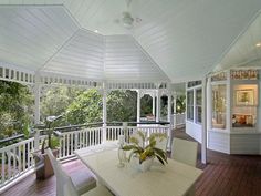 a white covered porch with table and chairs